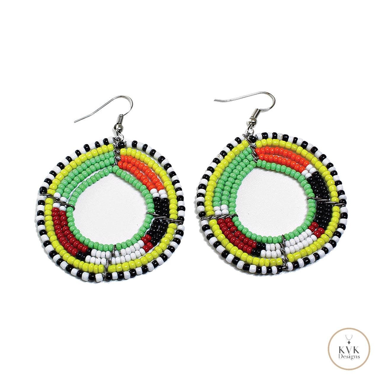 Colorful beaded earrings featuring circular designs in black, yellow, orange, green, and white. Each earring has multiple rows of beads arranged in layered patterns, hanging from metal hooks.