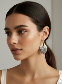 Oval-shaped silver and gold earrings. The earrings have a hammered silver oval with a gold-colored vertical accent and a gold-colored chain detail. The earrings are hanging from a gold-colored hook.